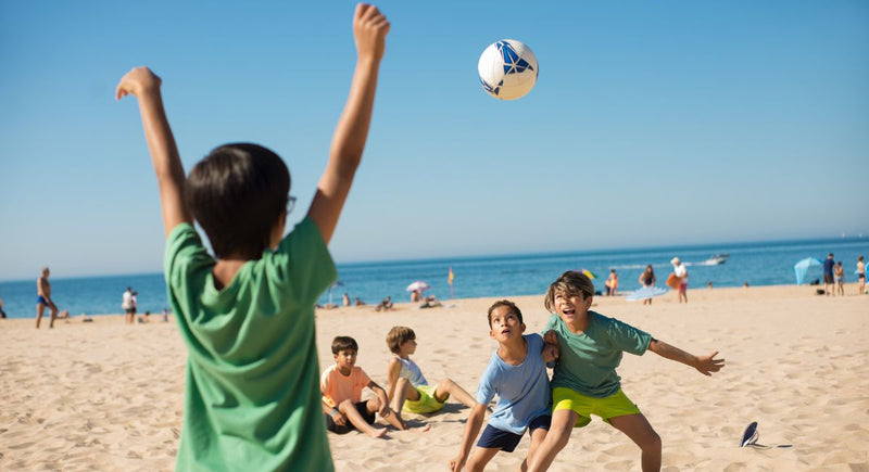 Crianças a jogar futebol na praia
